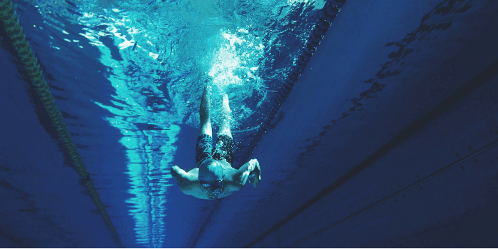 Underwater view of a swimmer gliding through a pool lane